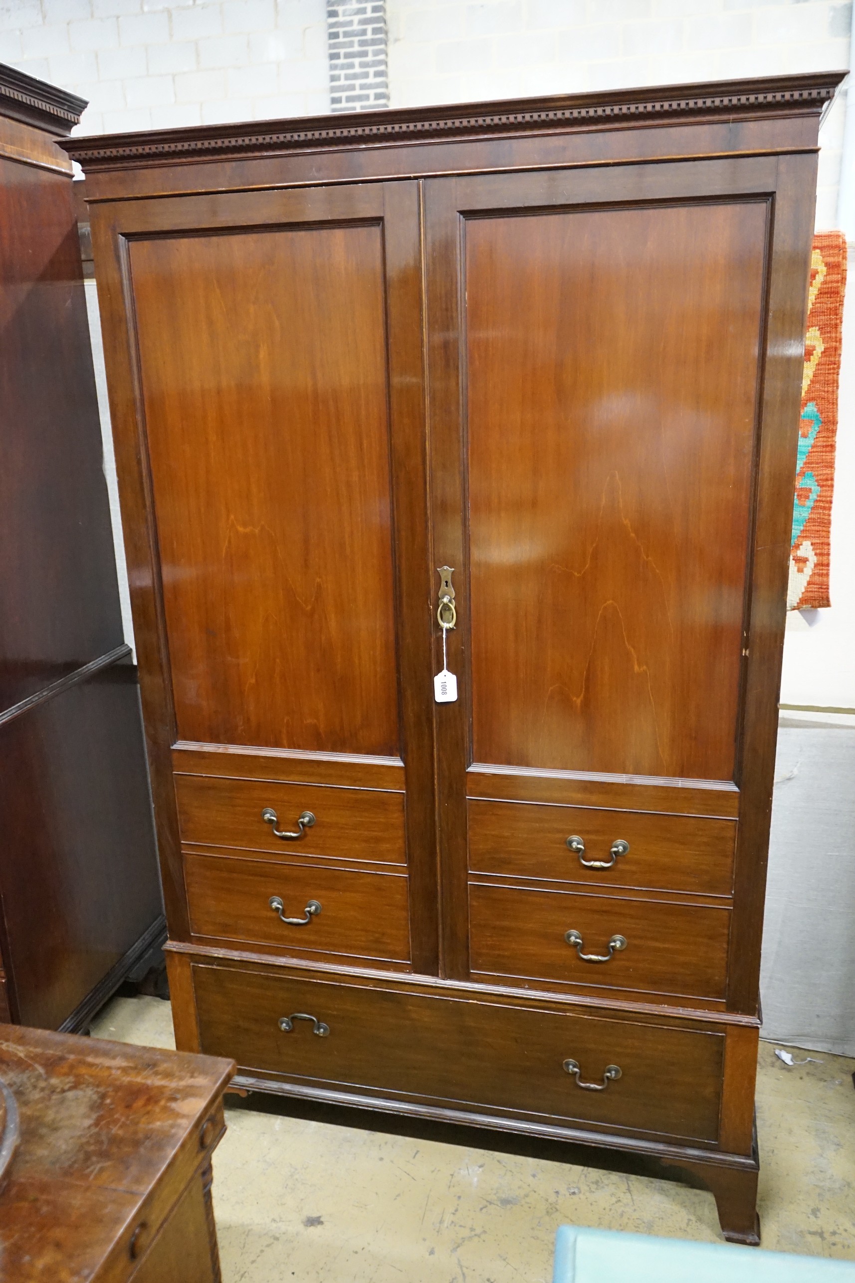 A 1920's mahogany press cupboard with part dummy drawer front over a single drawer, width 120cm, depth 50cm, height 196cm